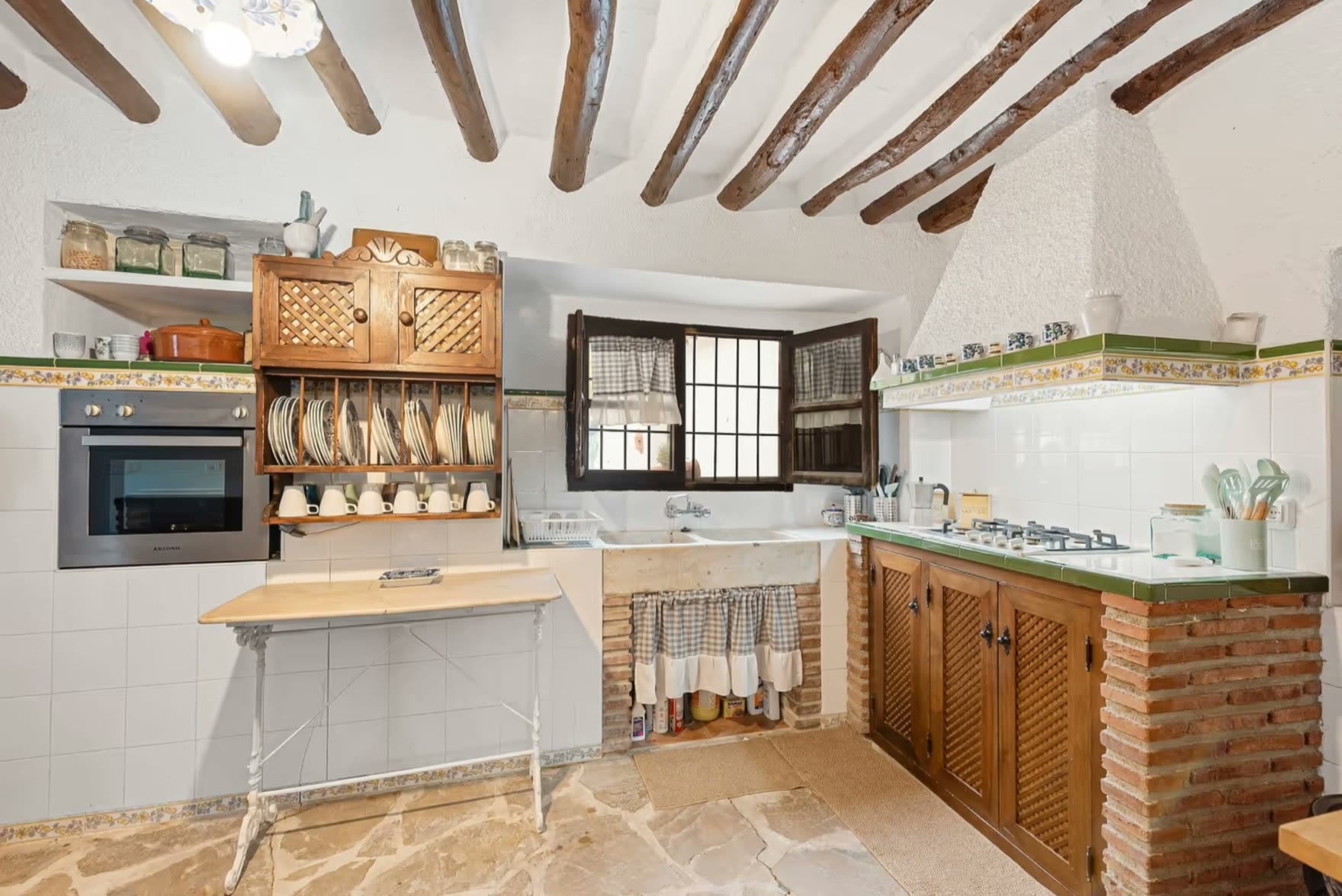 Cocina del Cortijo Caracate con vigas de madera y azulejos andaluces